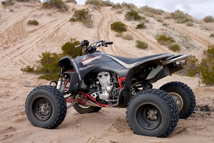 black ATV on brown soil